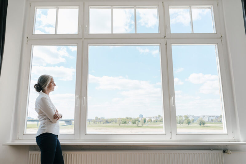 Woman Staring Out Large Picture Window